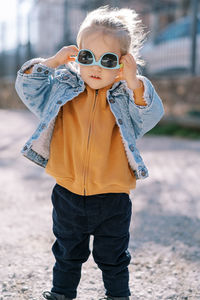 Low section of woman wearing sunglasses while standing outdoors