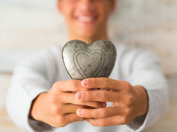 Midsection of woman holding heart shape