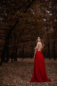 Portrait of woman with red umbrella in the forest