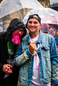 Portrait of a young couple holding hands in rain