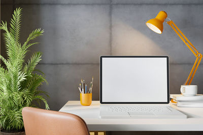 Low angle view of yellow and laptop on table