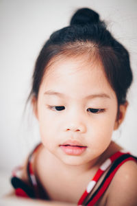 Close-up of cute girl looking away at home