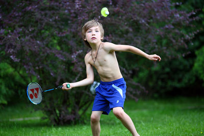 A 7 year old boy plays badminton.