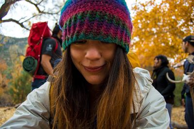 Close-up of young woman wearing knit hat on field during autumn