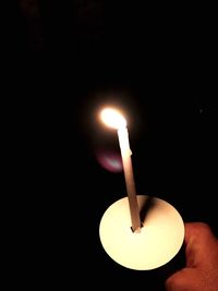 Close-up of lit candle in dark room