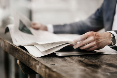 Businessman in cafe reading newspaper