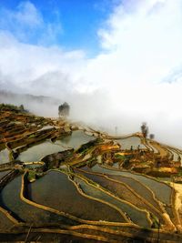 Aerial view of landscape against cloudy sky