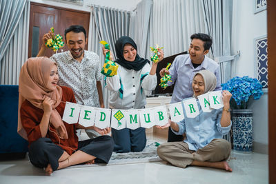 Portrait of smiling family sitting on bed at home