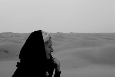 Side view of woman standing at desert