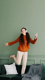 Joyful young woman dancing to her favorite music at home. happy girl experiencing joy while