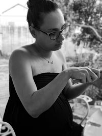Midsection of woman looking away while sitting outdoors
