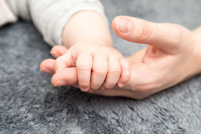 Close-up of father holding baby hand