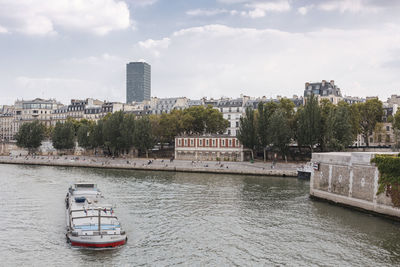 Scenic view of river by buildings against sky