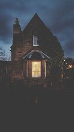 Illuminated building against sky at dusk