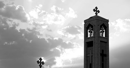 Low angle view of clock tower amidst buildings against sky