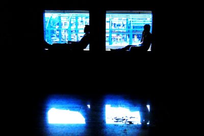 View of illuminated building through window