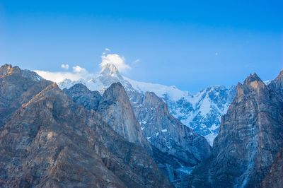 Panoramic view of snowcapped mountains against blue sky