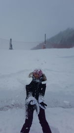 Rear view of child standing on snow covered landscape