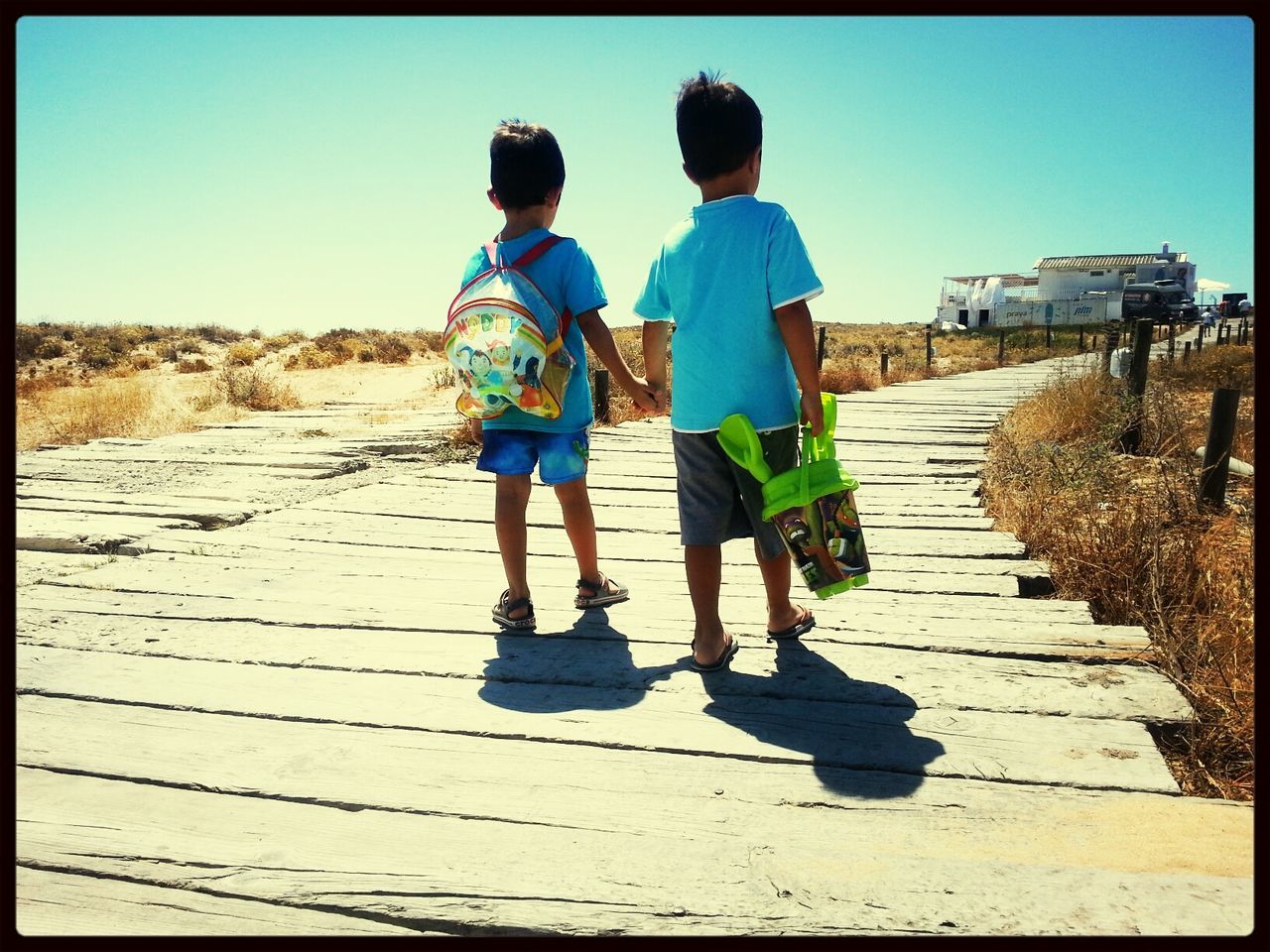 transfer print, full length, lifestyles, leisure activity, clear sky, childhood, auto post production filter, casual clothing, boys, sand, rear view, walking, togetherness, beach, sunlight, men, girls