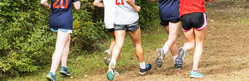 Low section of people running on grassland