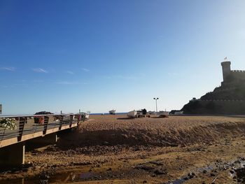 Scenic view of beach by buildings against sky