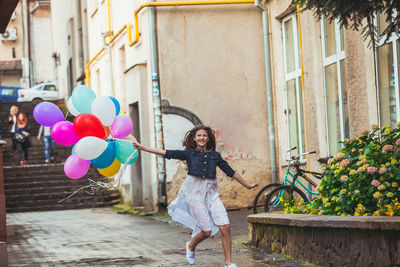Full length of woman holding balloons
