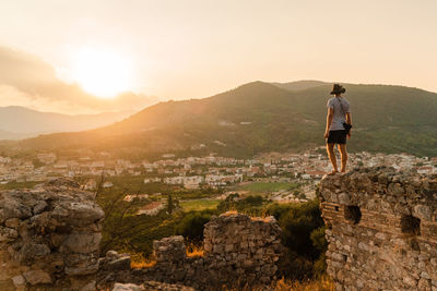 Rear view of man looking at mountains against sky