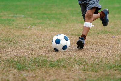 Low section of man playing soccer on field