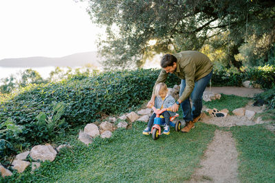 Side view of boy sitting on field