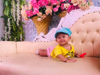 Full length of cute baby girl playing on sofa at event