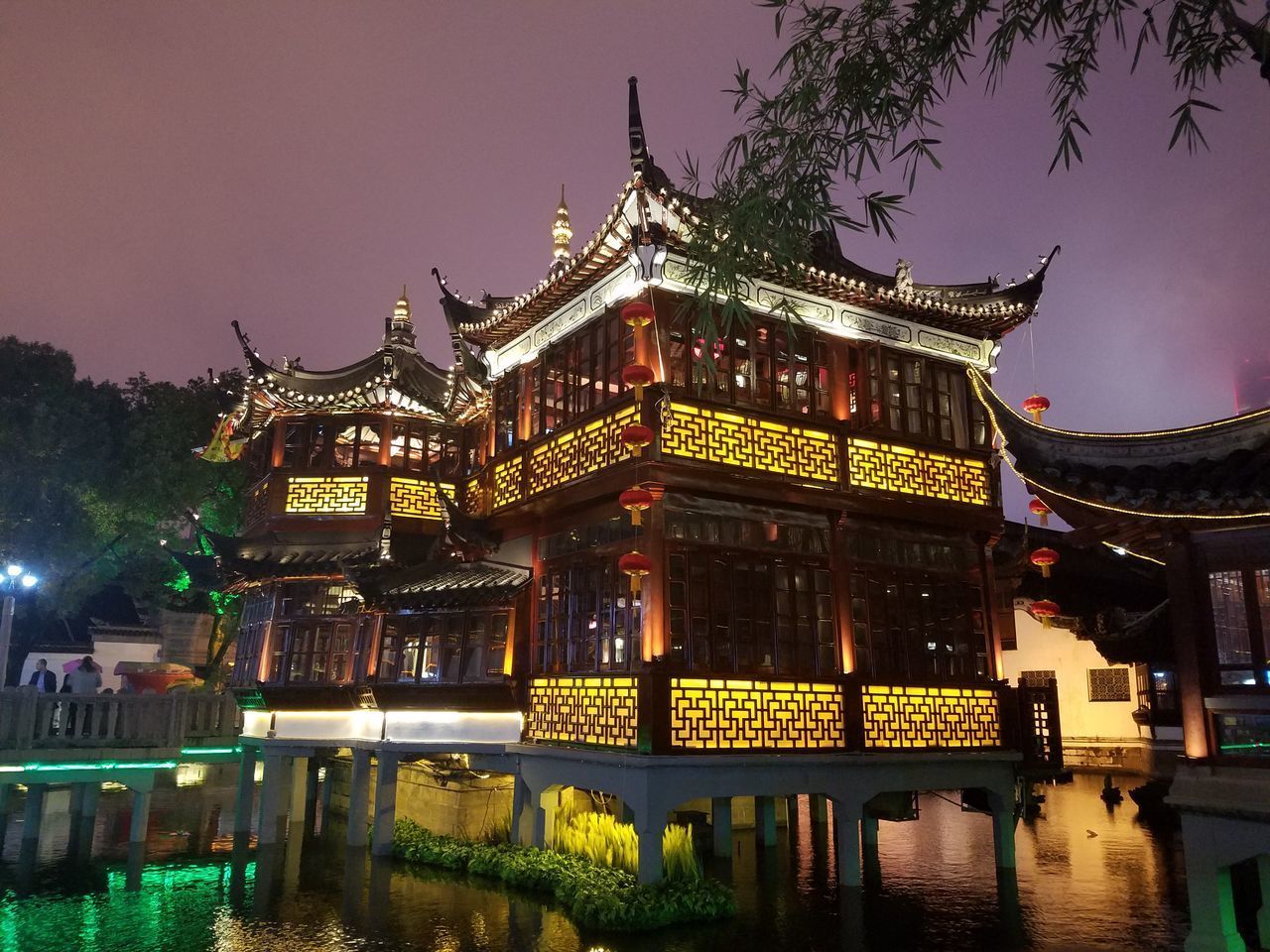 ILLUMINATED BUILDING BY LAKE AT NIGHT