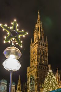 Low angle view of illuminated clock tower at night