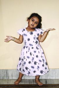 Portrait of girl standing against wall