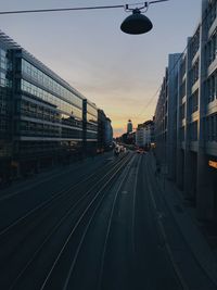 Railroad tracks in city at sunset