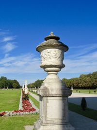 Statue in garden against blue sky