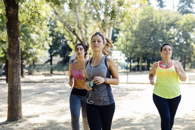 Young active female friends running in park