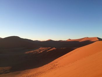 Scenic view of desert against clear blue sky