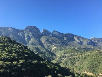 Scenic view of mountains against clear blue sky