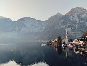 Scenic view of lake by buildings against sky