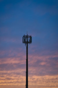 Low angle view of silhouette communications tower against sky during sunset