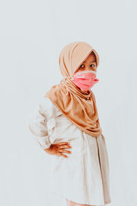 Portrait of a young woman against white background