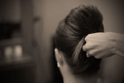 Cropped image of hands making hair bun of woman