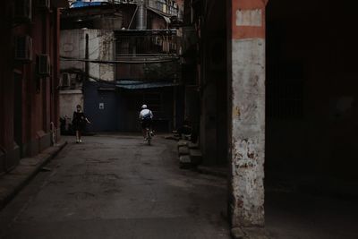 Rear view of people walking in abandoned building