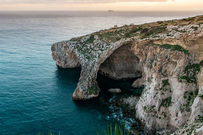 Rock formation in sea against sky