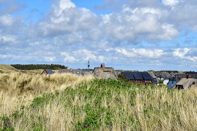 Houses on field against sky