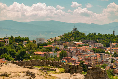 Buildings in town against cloudy sky