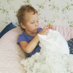 Boy removing cotton from pillow