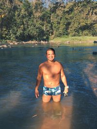 Portrait of shirtless man standing in water