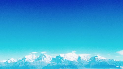 Snow covered mountain against blue sky