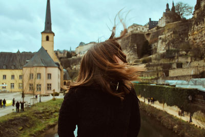 Rear view of woman standing against buildings